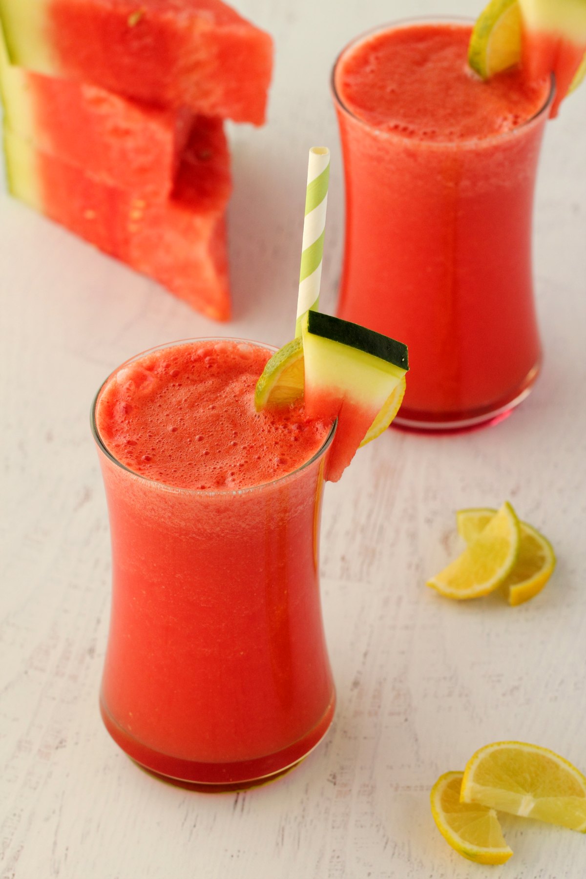 Watermelon Smoothie in a glass with a green and white straw. 