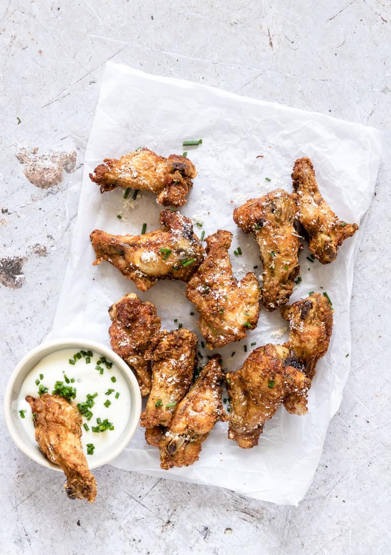 Air Fryer Chicken Wings served with dipping sauce and garnished with fresh herbs